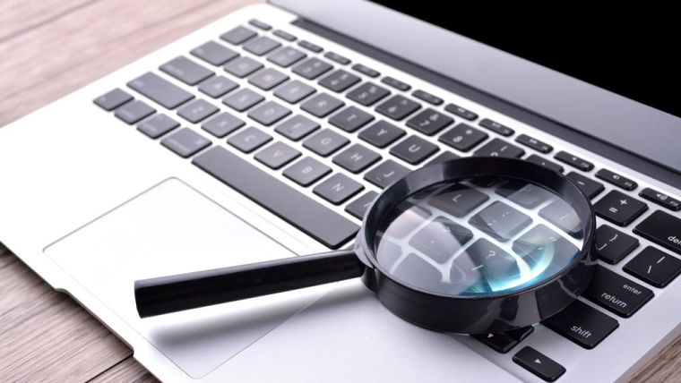 Close-up of laptop and magnifying glass