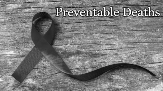 A black and white image showing a black curled ribbon on a wooden surface, with the words preventable deaths overlaid on it